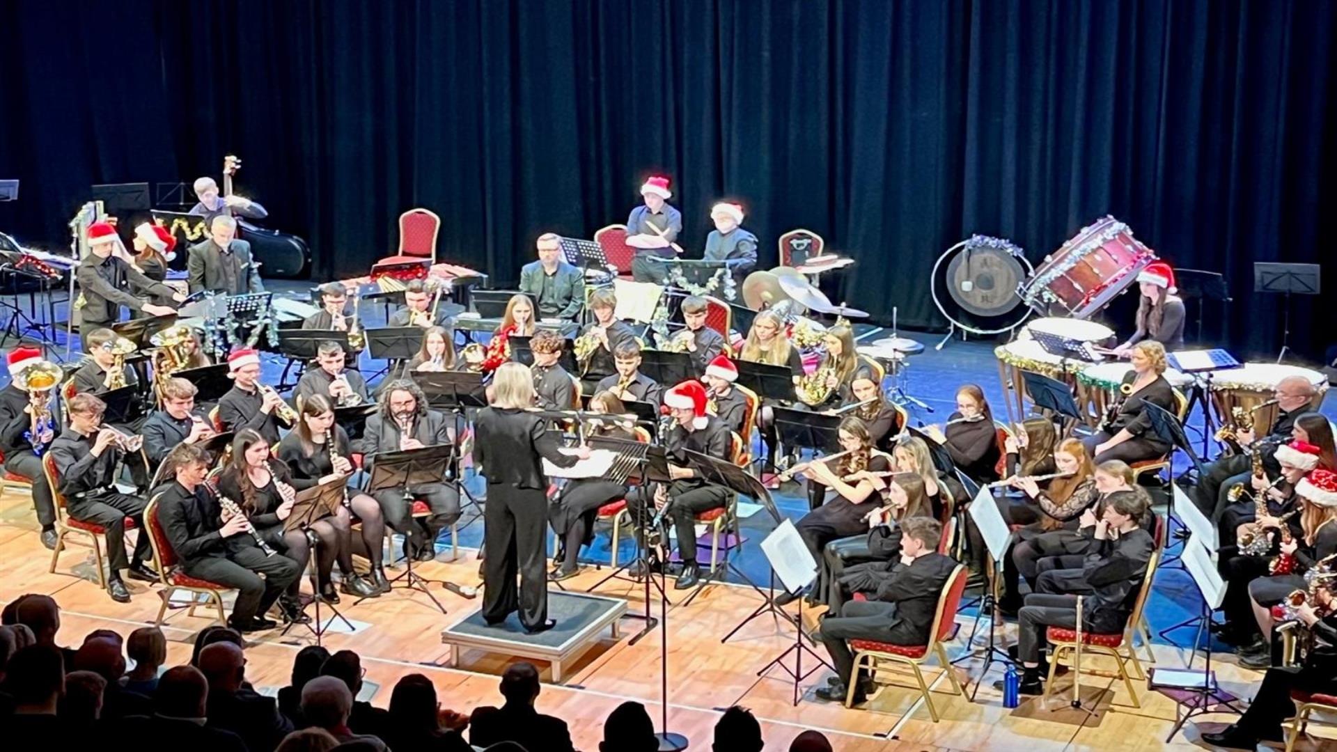 Image is of a orchestra and conductor on stage