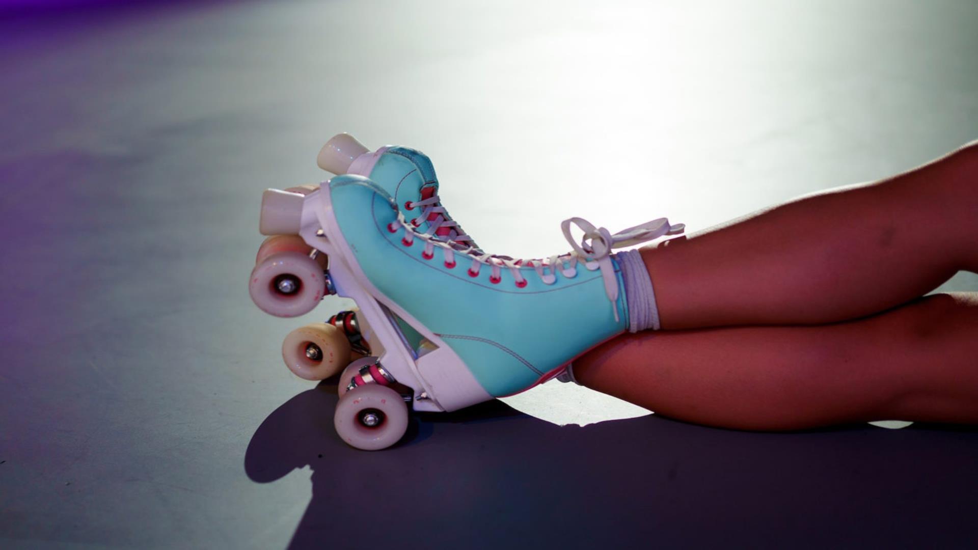 Image is of a pair of blue and pink roller skates