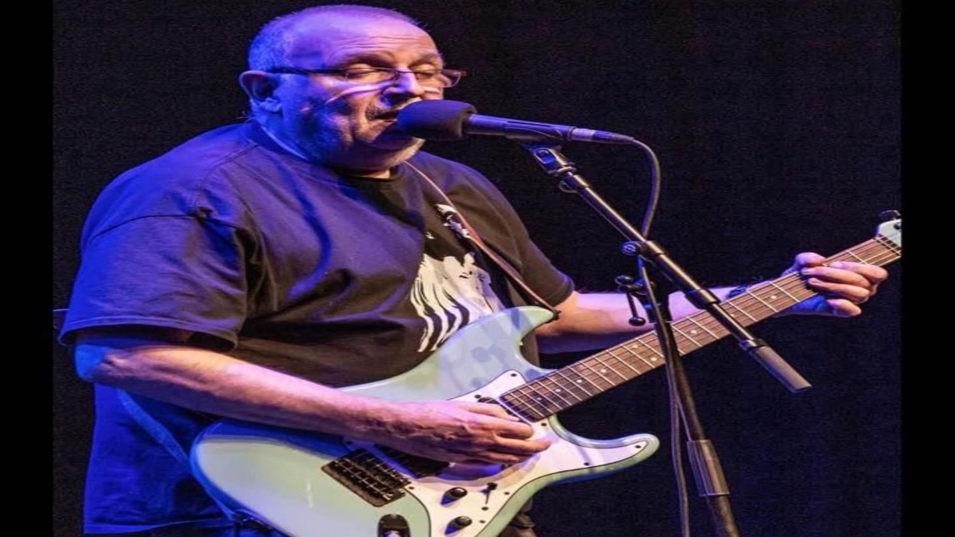 Image is of musician Ronnie Greer playing the guitar