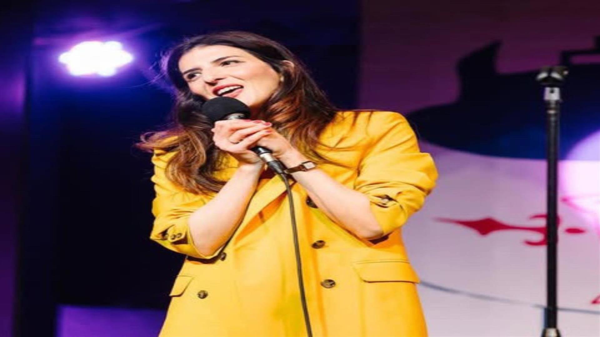 Image is of comedienne Wafa Daldoul on stage performing