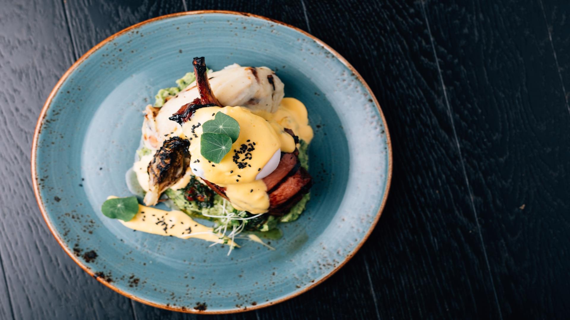 Image is of eggs and vegetables displayed on a round blue plate