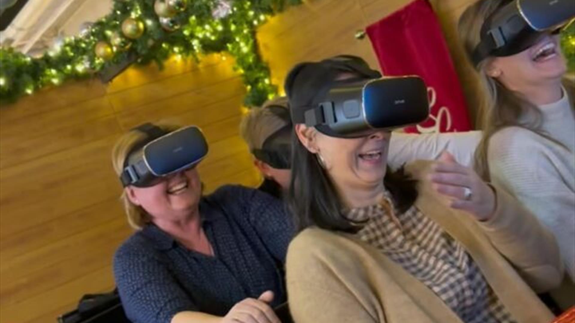 Image is of people taking part in a virtual reality sleigh ride