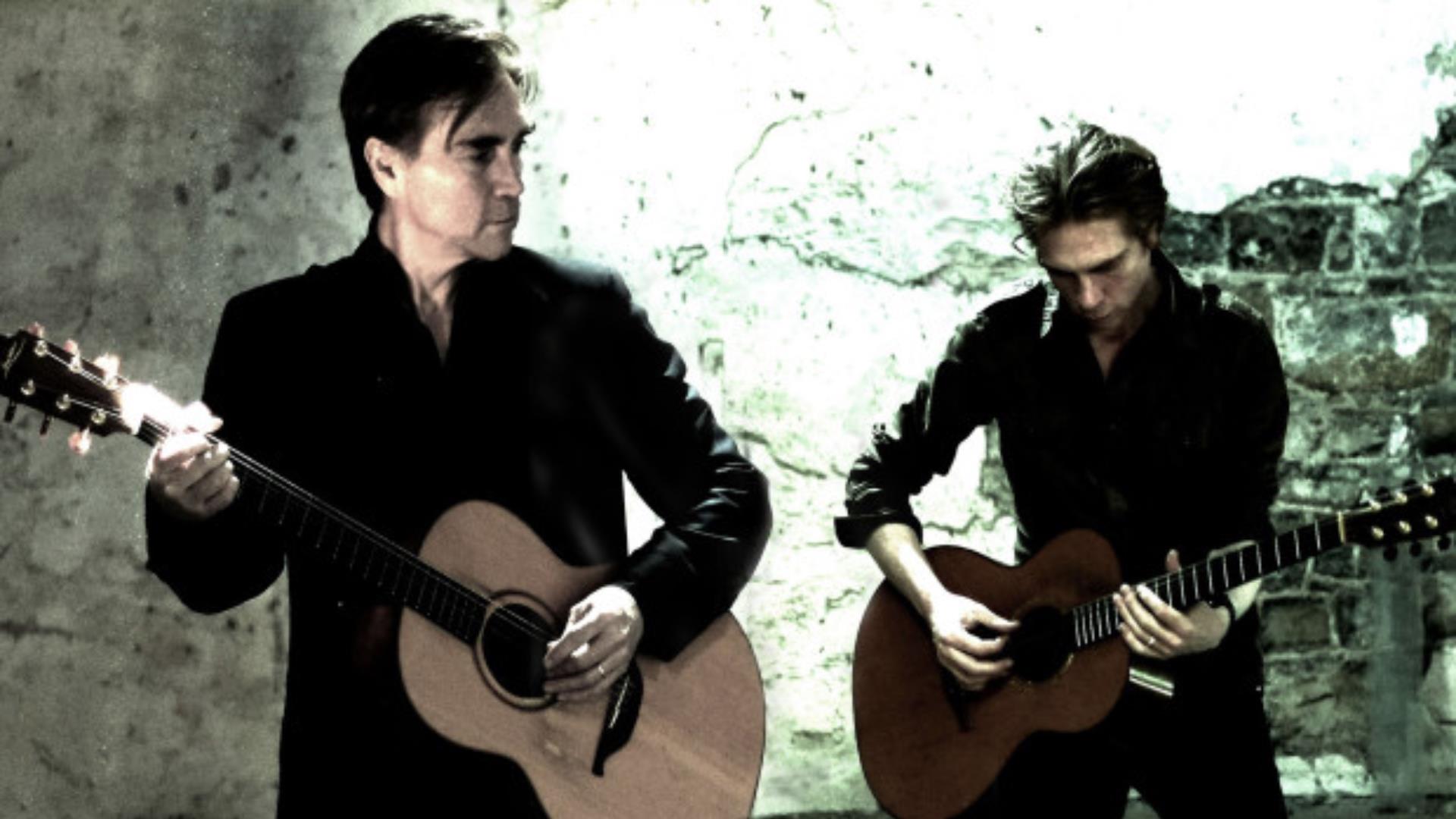 Two men playing guitar