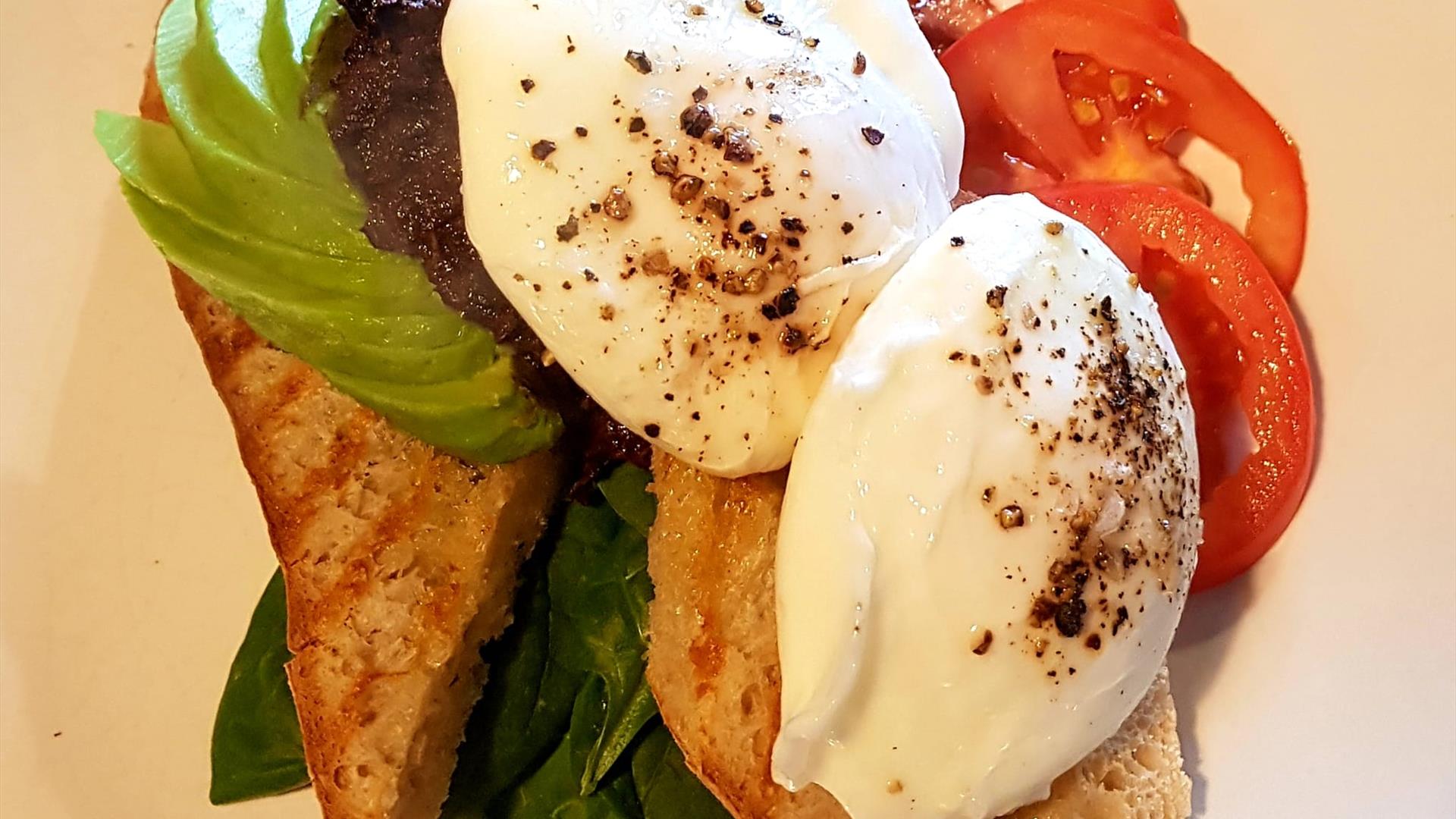 Image shows poached egg on toast with avocado, lettue & tomato.