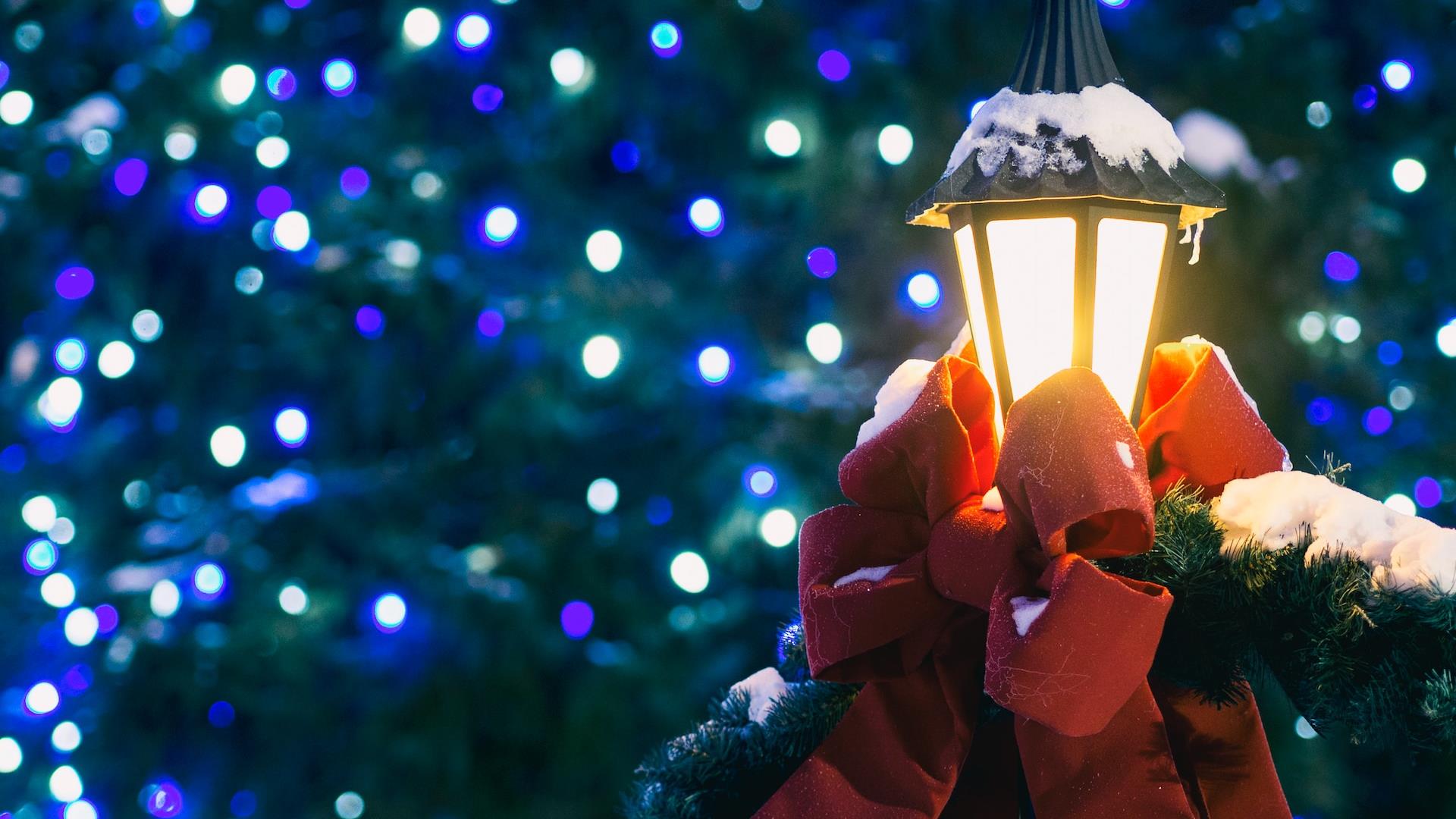 Christmas lights with a lantern wrapped in a red ribbon