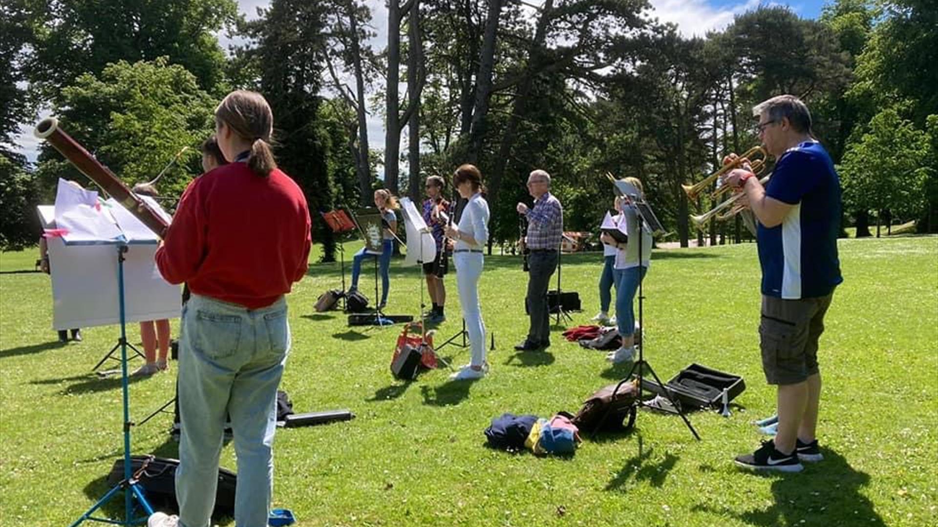 People in the orchestra playing in a park