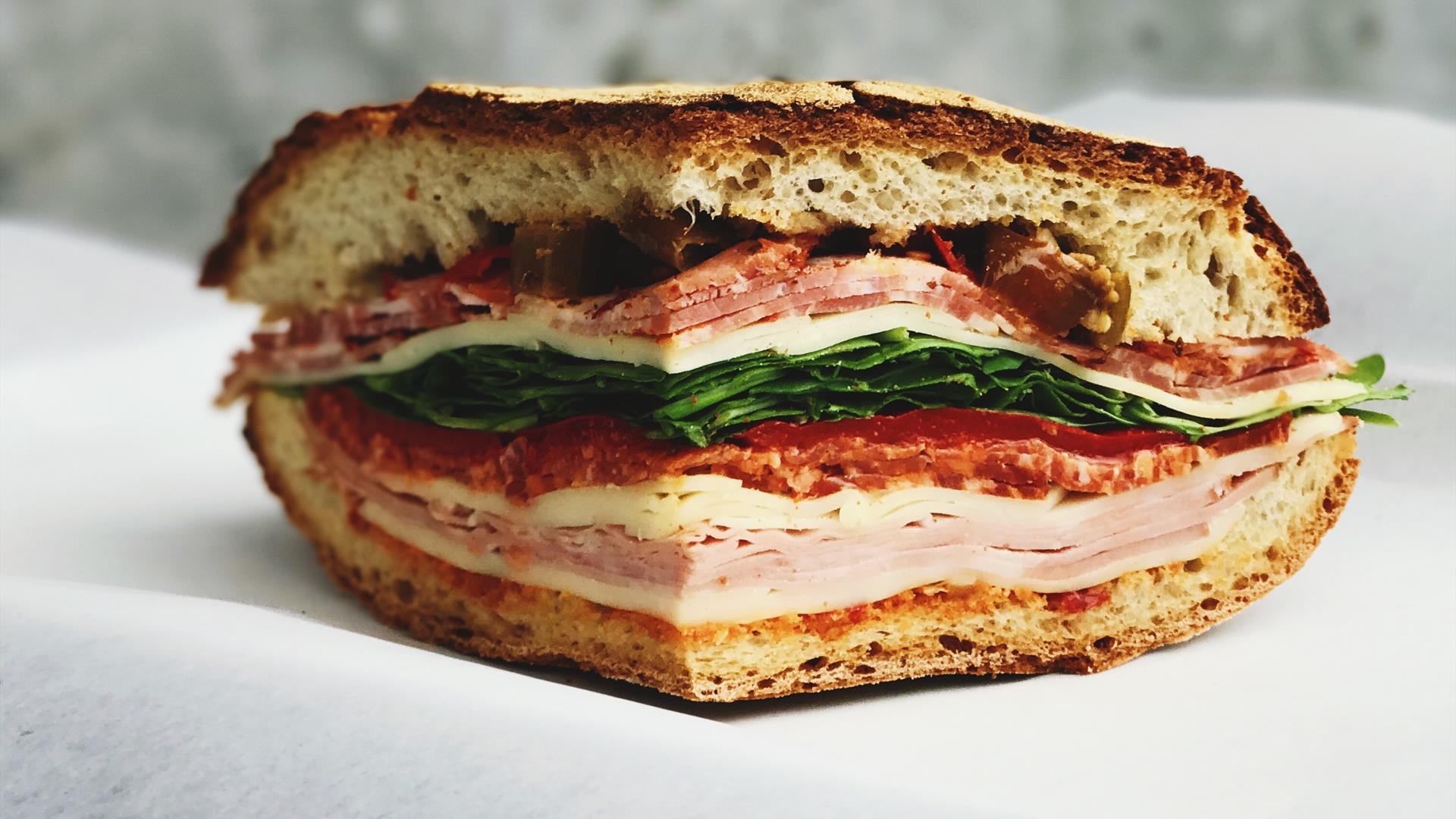 Image shows a sandwich with ham, chicken, bacon lettuce & tomato