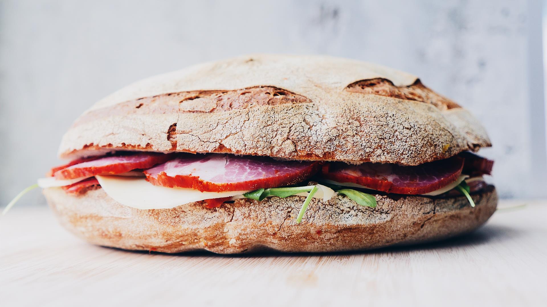 Image shows a ciabatta sandwich with ham and lettuce