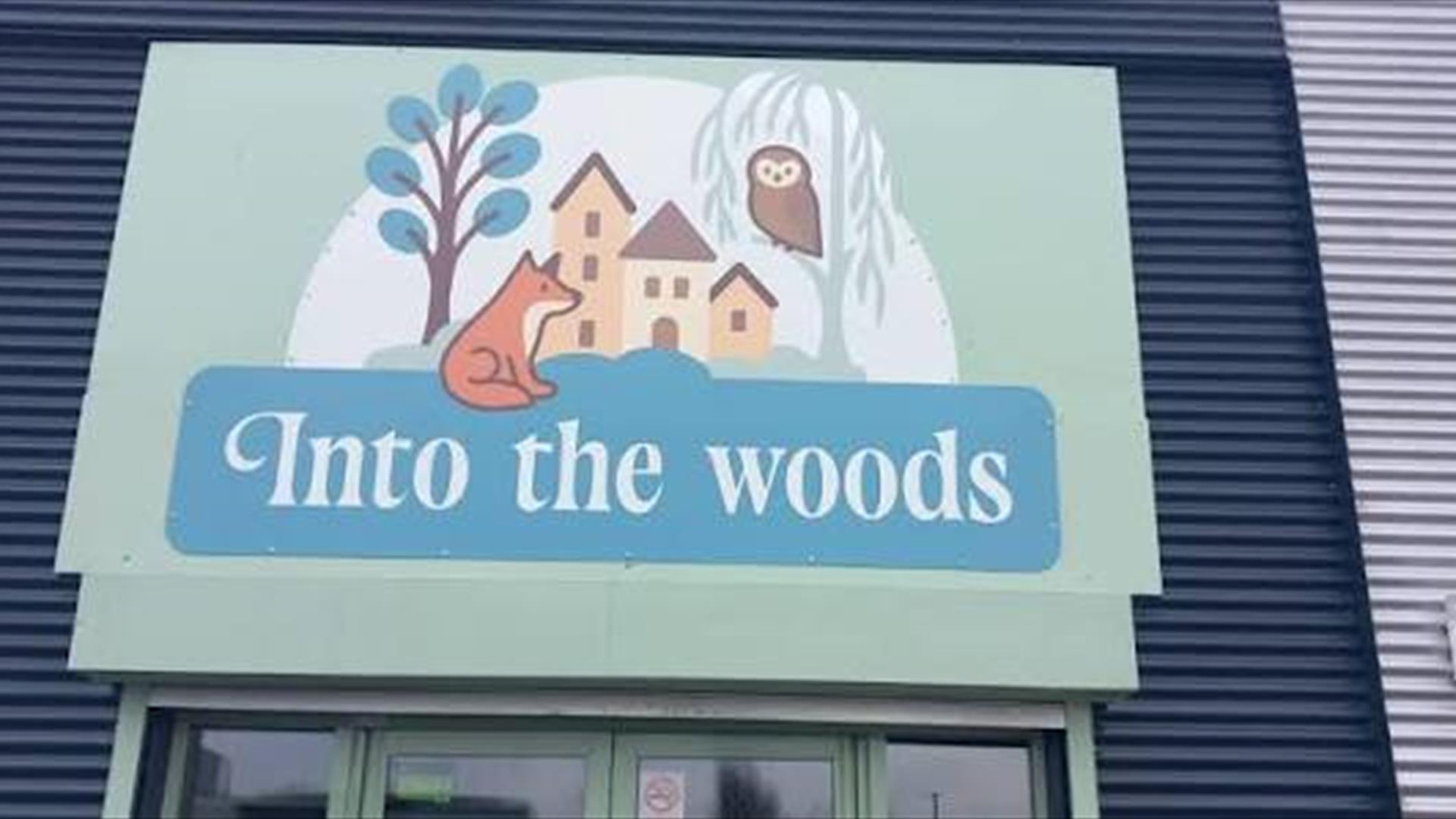 Into the Woods logo sign business name with fox, owl, tree and houses