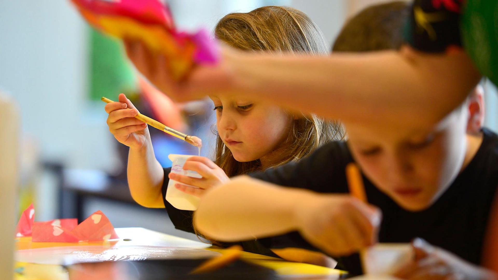 Two children working on a arts programme