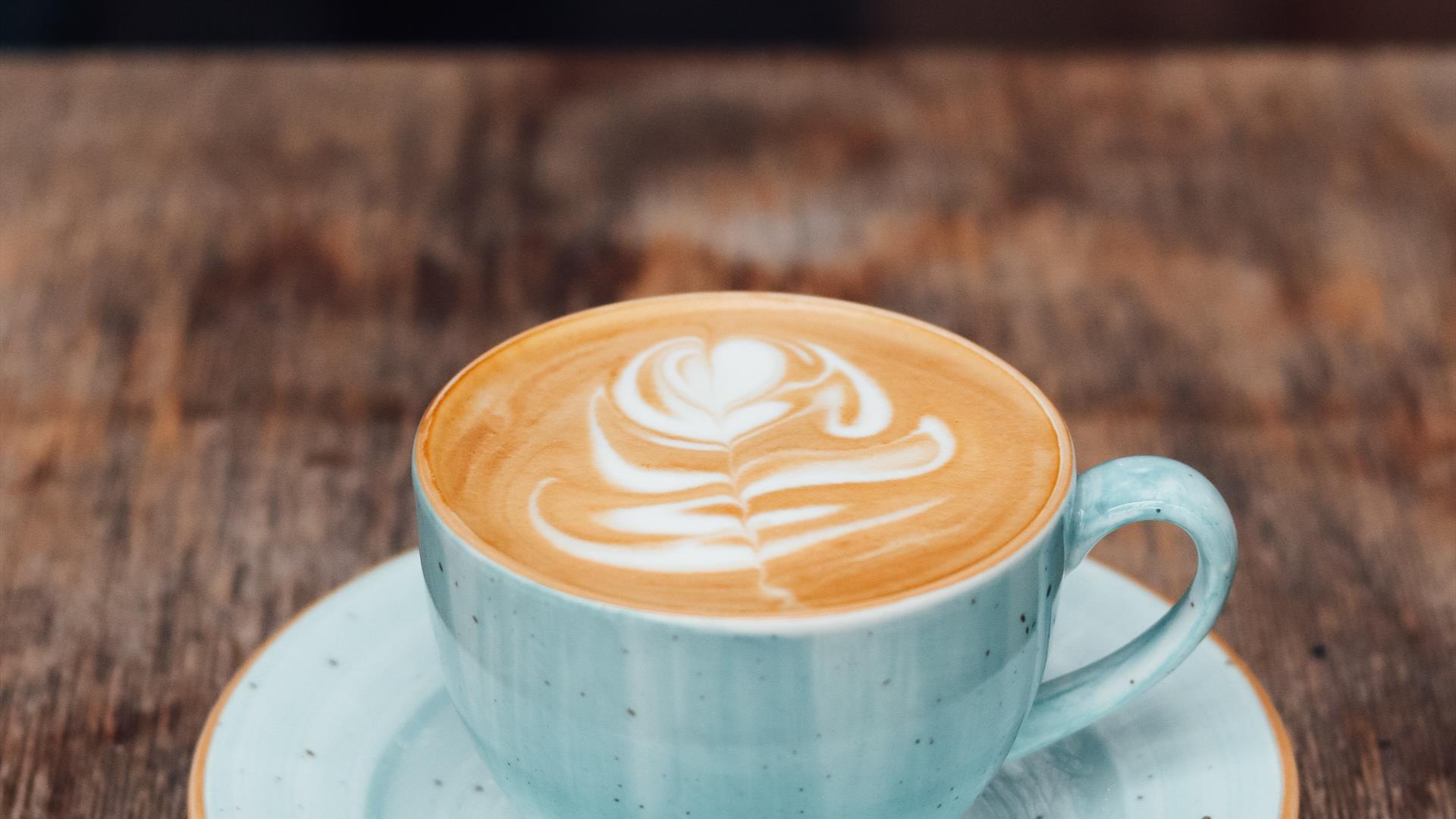 Image shows cup & saucer with latte coffee