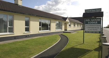 Image shows the front of the property with walk way and grass area
