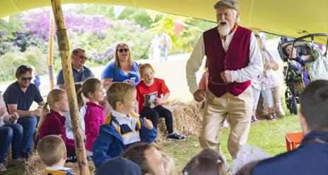 A storyteller is talking to children on the grounds of Hillsborough Castle and Gardens