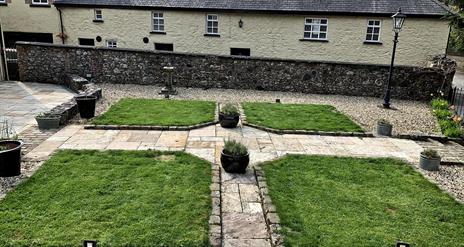 Image shows back of property with landscaped garden area