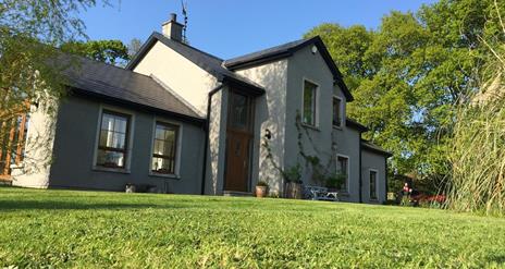 Image shows front entrance of the property with lawn at the front