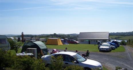 Image is of campsite with people sitting around