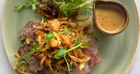 Image is of a plate of food and pot of sauce from Ashvale Farm Shop