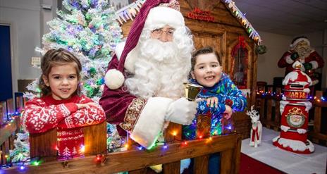 Image is of Santa Claus and children at his grotto