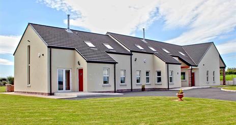 Image shows front of property with grassy area