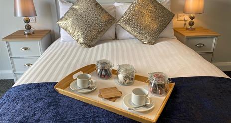 Image show breakfast tray on double bed in guest room