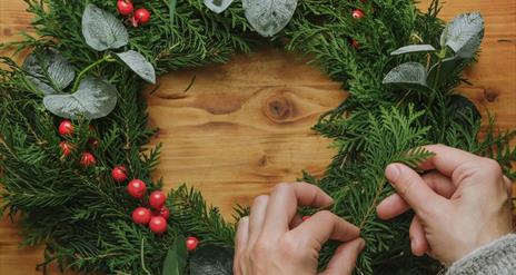 Image is of someone making a Christmas wreath