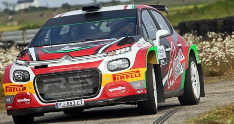 Rally Car on road at Down Rally with flowers in background