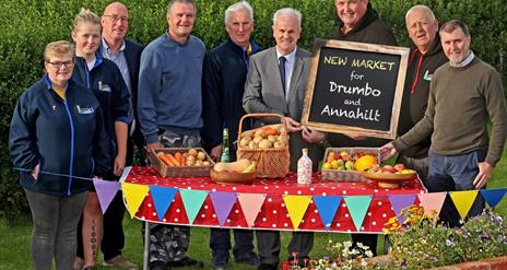 Image is showing members of the Association at a  table with different kinds of food available at the Country Market.