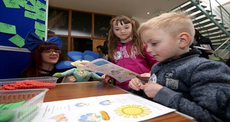 Image shows children sitting at a table looking at the Flaxie Trail