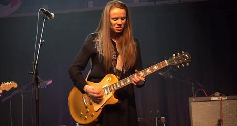 Grainne Duffy playing guitar on stage