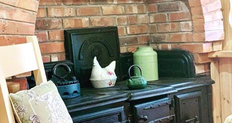 Image shows Aga in kitchen area with explosed brickwork surrounding it