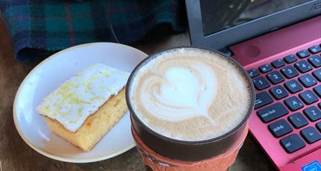 Image is of a cup of coffee and slice of cake in Ground Espresso