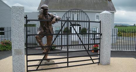 Sculpture of Harry Ferguson looking over his gate
