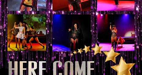 Image is of the various performers on the stage at Here Come The Girls show
