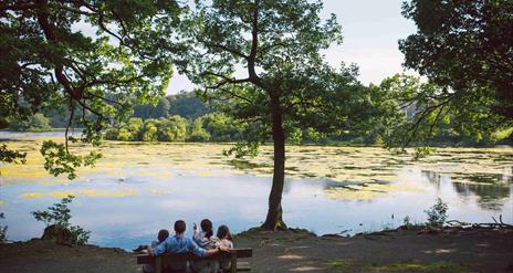 Family ona bench looking over the lake at Hillsborough Forest