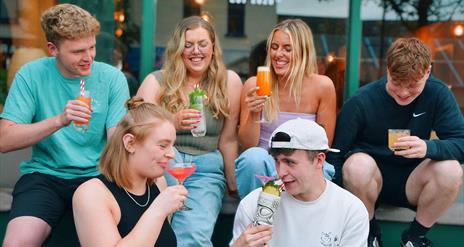 Joxer team sitting outside their restaurant drinking cocktails