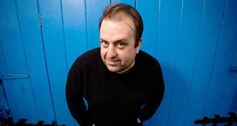 Picture of Karl Spain standing in front of a blue door