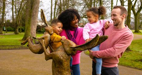 Family at Guess How Much I Love You sculpture in Castle Gardens, Lisburn