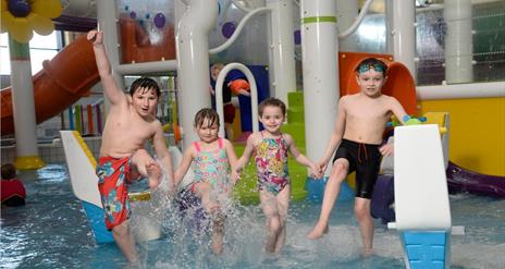 Image shows four children having fun splashing in the LeisurePlex children's pool