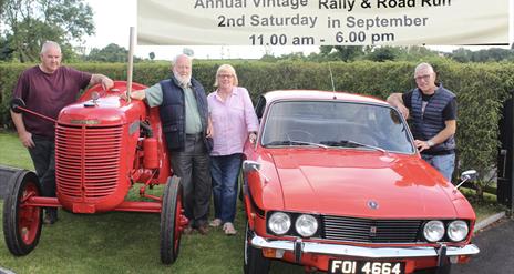 Image is of classic car and tractor with banner advertising Larchfield Community Fun Day