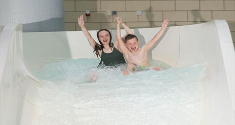 Image shows two children coming down slide in LeisurePlex