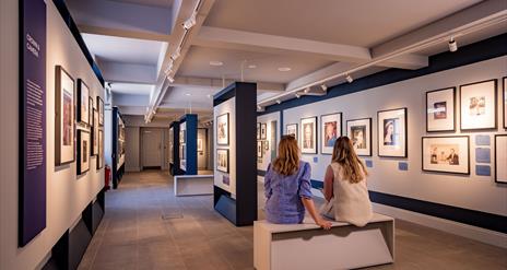 Visitors sitting at the Life Through A Royal Lense Exhibition