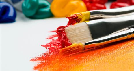 Image shows a variety of paint brush sizes and paint