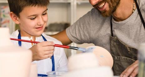Image shows Father and Son painting pottery.