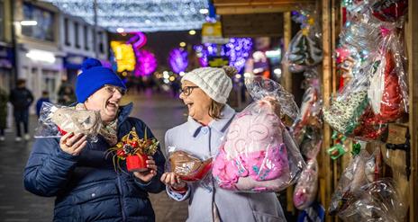 Image is of two ladies laughing and enjoying the Christmas Market in Lisburn