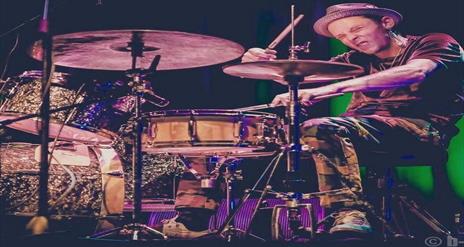Image is of a man playing the drums