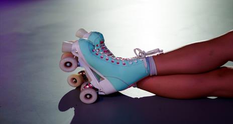 Image is of a pair of blue and pink roller skates