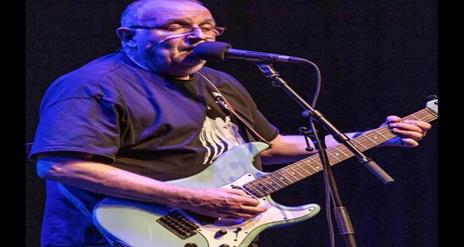 Image is of musician Ronnie Greer playing the guitar
