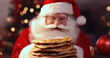 Image is of Santa Claus eating some pancakes