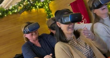 Image is of people taking part in a virtual reality sleigh ride