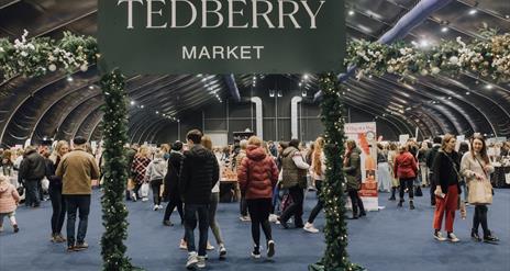 Tedberry Market sign with visitors and traders